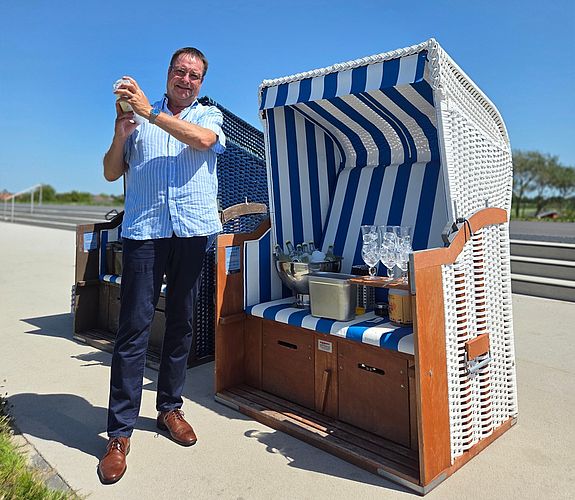 Bernd Dunker am Trischendiek Strand in Friedrichskoog vor dem Strandkorb beim Cocktail-Shaken