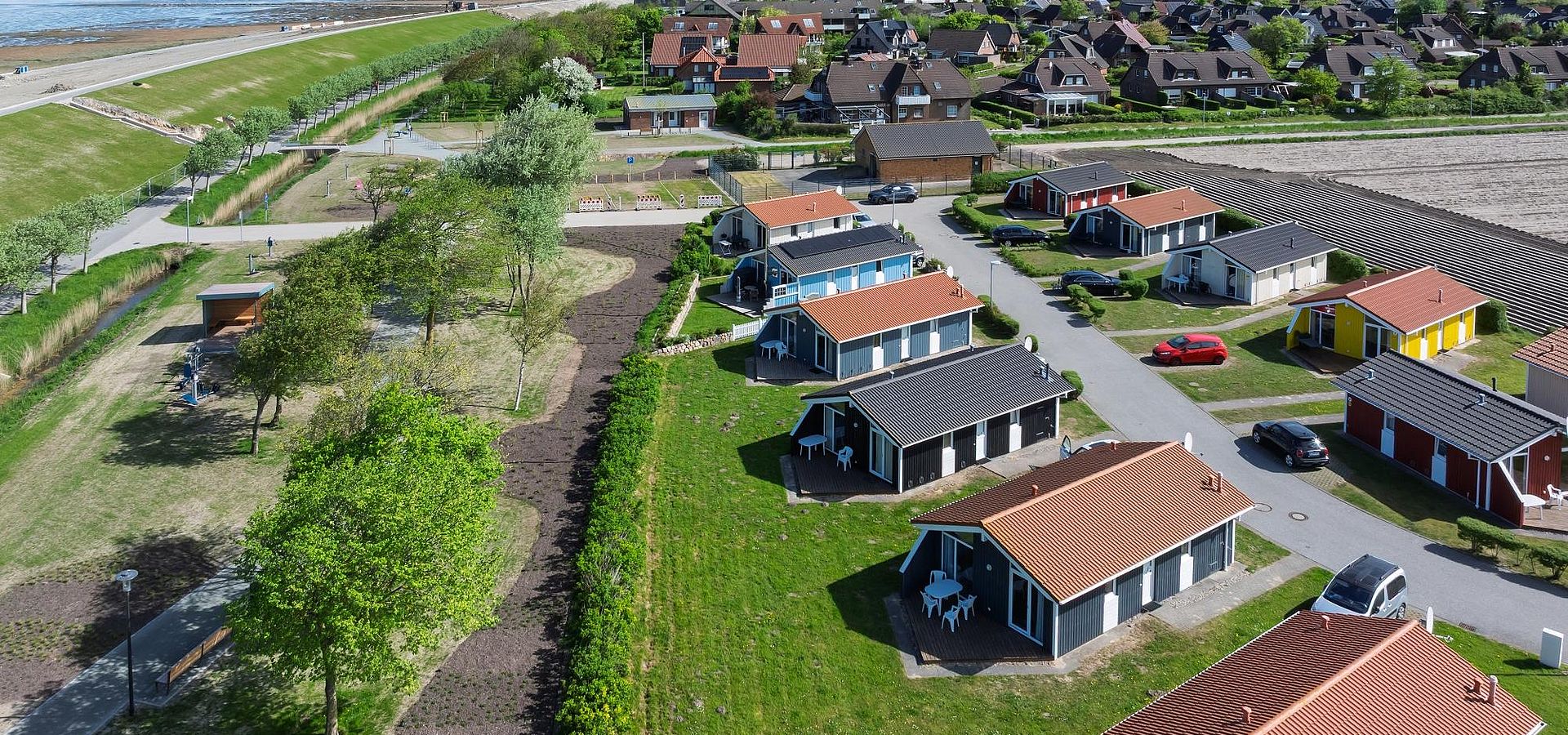 Der Trischendiek mit einer Reihe von Ferienhäusern aus der Vogelperspektive